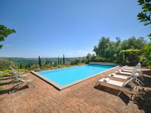 a swimming pool with chaise lounge chairs and a swimming pool at La Locanda Volpaia in Radda in Chianti