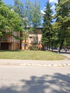 a building on the side of a street with trees at Centar Spa Teslic in Teslić