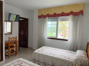 a bedroom with two beds and a window at Casa Rodiño in Meaño