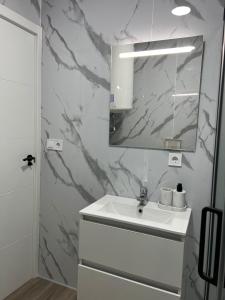 a bathroom with a white sink and a mirror at Apartment in Amer in Amer