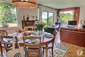 a kitchen and living room with a table and chairs at L'orée du bois in Ploumagoar