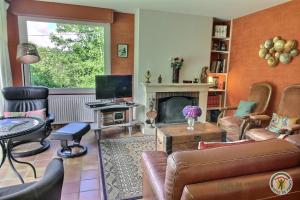 a living room with a couch and a fireplace at L'orée du bois in Ploumagoar