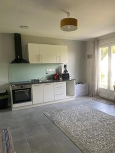 a kitchen with white cabinets and a large window at Era in Chancelade