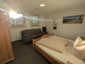 a bedroom with a bed and a couch at Appart Gfall in Ried im Oberinntal