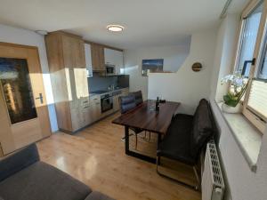 a living room with a table and chairs and a kitchen at Appart Gfall in Ried im Oberinntal +23 photos