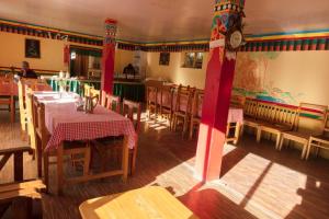 a restaurant with tables and chairs and a clock on the wall at Saser Camp in Nubra