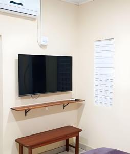 a flat screen tv on a wall with a wooden table at Casa Marajoara in Soure
