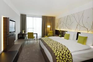 a hotel room with a large bed and a television at Atlantic Congress Hotel Essen, WorldHotels Elite in Essen +92 photos