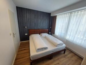 a large bed in a room with a large window at Pension Alpha in Frankfurt