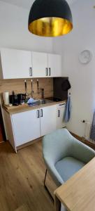 a kitchen with a sink and a chair and a table at Direkt am Wanderweg, Ferienwohnung im Allgäu nahe Oberstaufen in Oberstaufen +12 photos