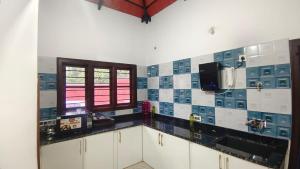 a kitchen with blue and white tiles on the wall at Greenview Homestay in Sakleshpur