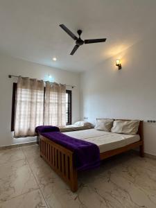 a bedroom with a bed and a ceiling fan at Greenview Homestay in Sakleshpur