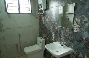a bathroom with a sink and a toilet and a mirror at Greenview Homestay in Sakleshpur +15 photos