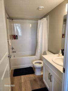 a white bathroom with a toilet and a sink at Heavenly Rest by JC in Edmonton +54 photos