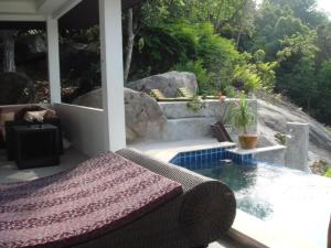 a bedroom with a bed and a pool on a patio at Ocean View Villa in Ko Tao