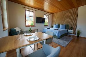 a room with a bed and a table and chairs at Direkt am Wanderweg, Ferienwohnung im Allgäu nahe Oberstaufen in Oberstaufen