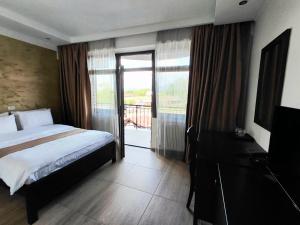 a hotel room with a bed and a balcony at DENY INN Funland in Zărneşti +42 photos