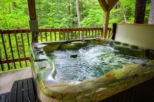 a hot tub sitting on a deck in a yard at Hemlock Hideaway in South Bloomingville