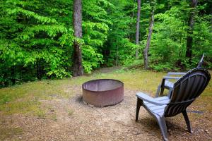 a chair and a fire pit in a yard at Hemlock Hideaway in South Bloomingville