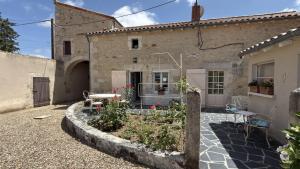 a courtyard of a house with a garden at Le gîte du porche in Saint-Georges-lès-Baillargeaux