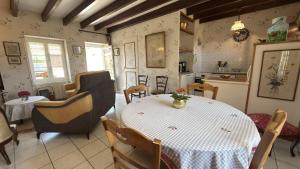 a kitchen and dining room with a table and chairs at Le gîte du porche in Saint-Georges-lès-Baillargeaux