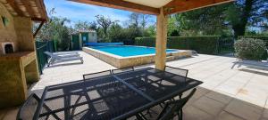 a patio with a table and chairs and a swimming pool at La Ferme Terre Bio Provence in Lapalud +51 photos
