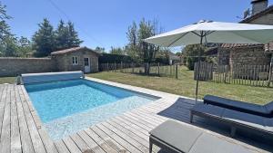a swimming pool with an umbrella and a chair at Lascaux in Saint-Mathieu +25 photos