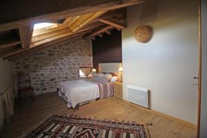 a bedroom with a bed and a brick wall at Lascaux in Saint-Mathieu
