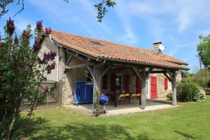 a wooden pavilion with a red door in a yard at Lascaux in Saint-Mathieu