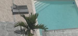 a palm tree in front of a building with a blue sky at Hannabi Hotel in Boca Chica
