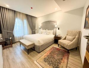 a large bedroom with a bed and a chair at Pak Hospitality in Islamabad