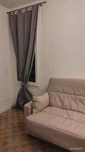a couch in a living room with a window at T2 dans le centre historique de Manosque in Manosque