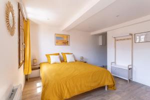 a bedroom with a yellow bed with a yellow blanket at Suite du Soleil - Studio - Hypercentre in Narbonne