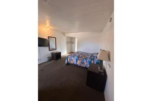a hotel room with a bed and a tv at Desert Sands Denton near UNT I 35 TX in Denton