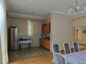 a kitchen with a table and a stainless steel refrigerator at Вилла Витязь in Chok-Tal