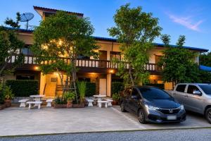 two cars parked in a parking lot in front of a building at กัลยา รีสอร์ท in Ban Bang Saen (1)