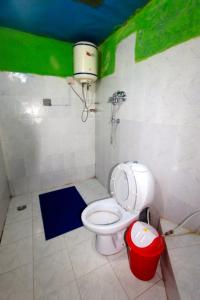 uma casa de banho com WC e um balde na parede em Himalayan Lodge em Nāmche Bāzār