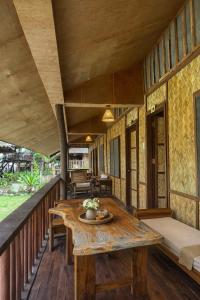 a room with a wooden table on a balcony at D Mountain Beach Resort - Beachfront in Puerto Galera
