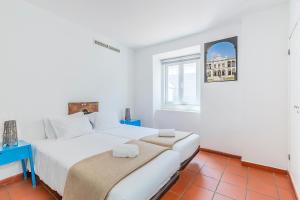 a white bedroom with a large bed and a window at HI Évora – Pousada de Juventude in Évora +45 photos