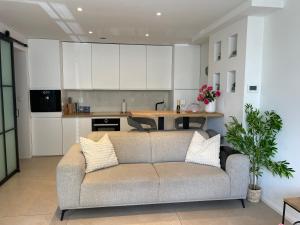a living room with a couch in front of a kitchen at Beach House Rodine - free parking & bikes in Scheveningen