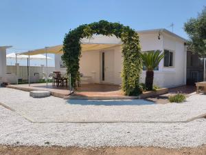 a garden with an arch in front of a house at DolceApulia Country House in Conversano