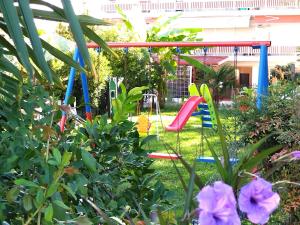 a colorful swing in a garden with flowers at Iris by Dias in Olympic Beach