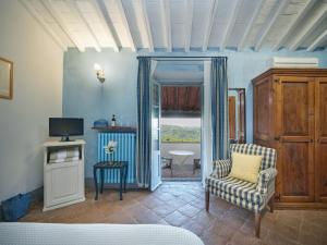 a living room with a chair and a television at La Locanda Volpaia in Radda in Chianti