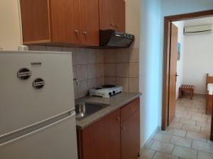 a kitchen with a refrigerator and a sink at Iris by Dias in Olympic Beach