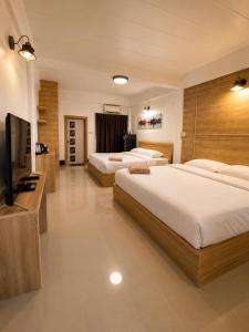 a hotel room with two beds and a flat screen tv at กัลยา รีสอร์ท in Ban Bang Saen (1)