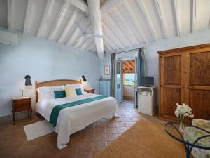 a bedroom with a large white bed and a tv at La Locanda Volpaia in Radda in Chianti +84 photos
