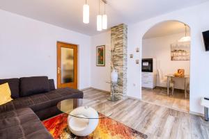 a living room with a couch and a glass table at Apartman Doris in Lovran +11 photos