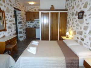 una camera da letto con un grande letto con asciugamani di Villa Peristeri ad Agios Georgios