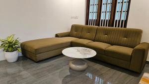 a living room with a couch and a table at Villa Terra, Spacious 2BR Villa in Kannur