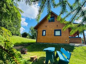 a wooden house with two chairs in front of it at Modrá chata pod horou in Mračkov